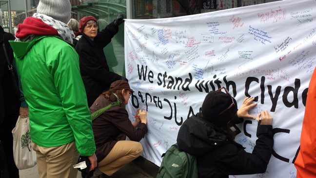Torontonians sign a banner that reads 