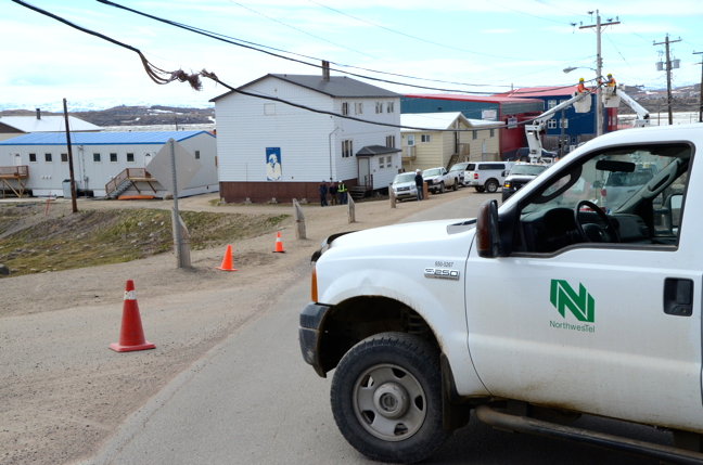 Five Northwestel service trucks are blocking Queen Elizabeth Way in Iqaluit to fix damage to a cable June 17. Approximately 1,000 Iqaluit residents lost phone and data service this morning because of the damage. “Northwestel personnel are currently focused on restoring services, and have prioritized emergency services at Iqaluit hospital,” a Northwestel media advisory said. The advisory said the damage to the cable is “significant” and they don’t know when they can restore phone and data services. “Residents should be prepared to be without service for longer than 24 hours.” (PHOTO BY DAVID MURPHY)