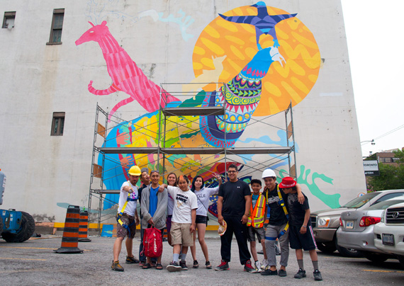 The side of this Toronto youth hostel has quickly come to life this week, thanks to the artistry of four Cape Dorset youth — Audi Qinnuayuaq, Latch Akesuk, Cie Taqiasaq and Parr Etidloie — who are working with a number of Toronto organizations to create the giant mural. The image is of one the boy’s grandfather carrying a broken-down snowmobile on his back through the streets of Cape Dorset, surrounded by Arctic wildlife. (PHOTO BY TOBIN GRIMSHAW)