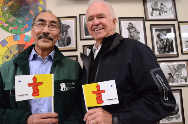 Nunavut Cabinet Minister Paul Quassa and former Indian Affairs Minister Tom Siddon — two men who both have their signatures on the 1993 Nunavut Land Claims Agreement — reunite at Inuksuk High School in Iqaluit, 22 years after the agreement was signed in 1993. On his return to Iqaluit for Nunavut Day, July 9, Siddon brought with him a carving, done by Jake Kadluk of Igloolik, representing a man cutting snow blocks for an iglu, a gift given to Siddon for the part he played in helping to negotiate the land claim agreement.