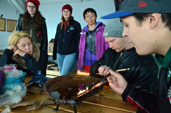 Devon Hoover-Ionson and Robert Comeau (right) maintain a qulliq at a workshop July 7 in Iqaluit. (PHOTO BY DAVID MURPHY)