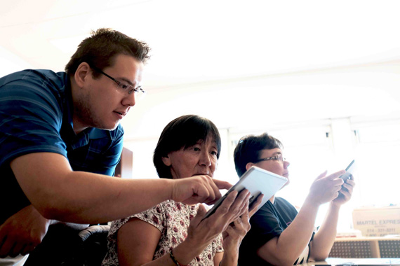 Post-secondary graduate Peter Annahatak offers help to Sarah Pirti, an Inuktitut grade 4, 5 and 6 teacher from Akulivik, as part of the course called Integrating Technology in the Classroom. It's one of six courses offered as part of the Kativik School Board's teacher training summer session held this year in Kuujjuaraapik from June 26 to July 3. The KSB's teacher Training program, offered in partnership with McGill University, takes the average Nunavimmiut teacher between five and seven years to complete and earn their Quebec teaching certificate. (PHOTO BY JADE DUCHESNEAU BERNIER)