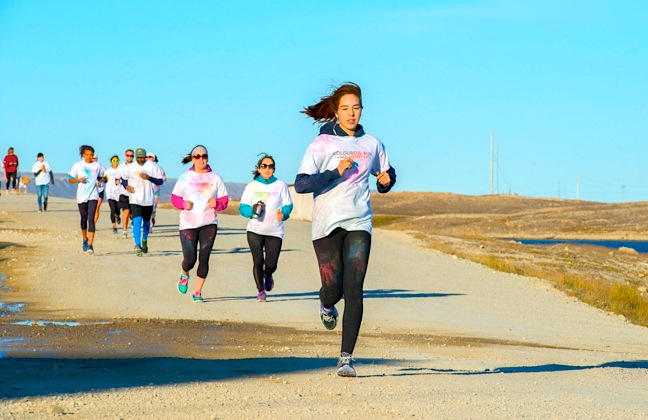 Runners and walkers in Cambridge Bay don T-shirts and splash them with paint powder for the annual colour run in that western Nunavut community Aug. 27. Promoted by community justice as an opportunity to stay active and healthy, the annual free race — several kilometres long — began at 6:30 p.m. and by 7:30 p.m., all participants had returned to the community hall. (PHOTO BY DENISE LEBLEU IMAGES)