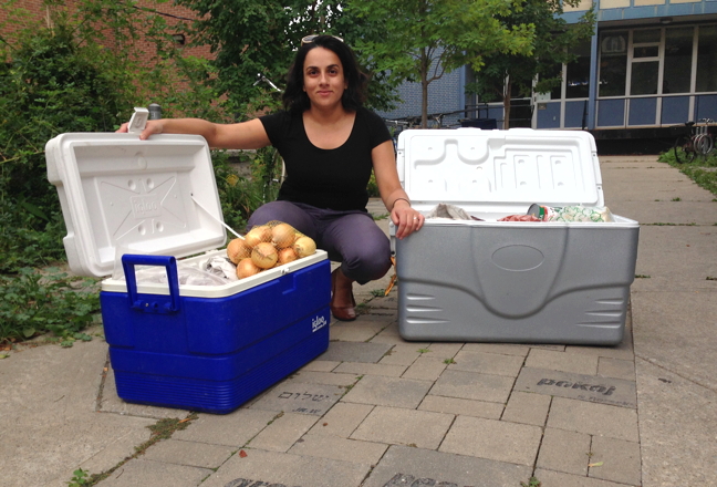 Greenpeace Canada staffer Farrah Khan poses with a couple of coolers of food she's bringing to Clyde River this week for a feast the environmental organization plans to host in that North Baffin community. Clyde River Mayor Jerry Natanine brought the silver cooler full of country foods to share during court proceedings in Toronto in April so Khan said she's returning the gesture. (PHOTO COURTESY GREENPEACE CANADA)