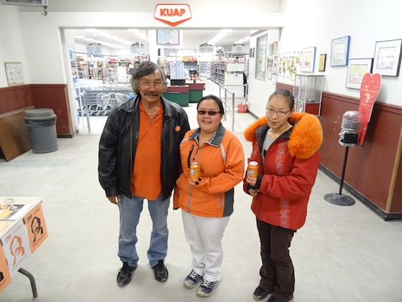 All in orange: Mary Anavilok and Janet Anavilok — who at 18 plans to vote Oct. 19 for the first time — stand with Jack Anawak, the NDP's federal candidate in Nunavut, Sept. 19 in the lobby of the co-op store in the western Nunavut town of Cambridge Bay. (PHOTO BY JANE GEORGE)
