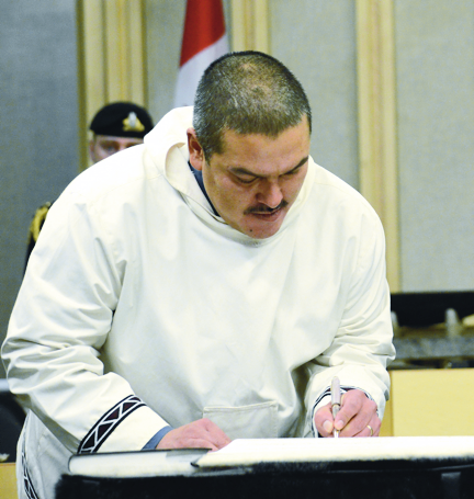 Samuel Nuqingaq signs his oath of office Nov. 19, 2013, as the official member for Uqqummiut. The disgraced MLA pleaded guilty Oct. 29 in Qikiqtarjuaq to being unlawfully in a dwelling house. The Crown stayed a charge of assault. (FILE PHOTO)