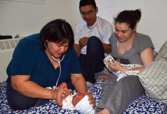 Salluit midwife Maggie Tayara listens to three-day-old Hannah-Skai's heartbeat during a home visit with the baby's parents in 2014. Nunavik's Hudson coast has three newly-certified midwives: Saira Kakayuk and Lizzie Sakiagak Tayara of Salluit, and Mary Ittukallak of Puvirnituq. (FILE PHOTO)