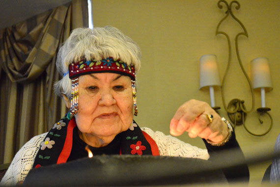 Maria Brazeau, who's originally from Nunatsiavut, tends a qulliq at the opening of the national meeting of urban Inuit that began Nov. 5 in Ottawa. (PHOTO BY JIM BELL)