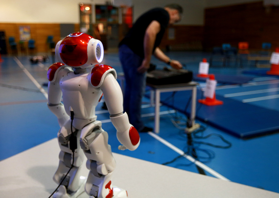 A technician sets up equipment in the gymnasium at Kiluutaq school in Umiujaq Nov.16, while NASA’s robot NAO looks on. Students at the Nunavik school will be making contact with the International Space Station today, Nov. 17, while the space station travels above the region, about 400 kilometres away. The program, which has visited a number of schools across the eastern Arctic, is coordinated by the Amateur Radio on the International Space Station, the Canadian Space Agency and NASA, and funded with support from Makivik Corp., First Air and Air Inuit. (PHOTO BY GILLES BOUTIN)