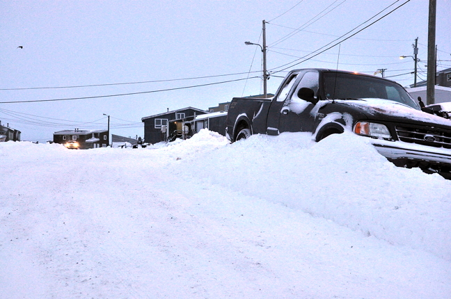 A pick-up truck sits abandoned in a snowbank near Iqaluit's old cemetery Jan. 12. This truck has been stranded since the holidays; snowfall and snowplows keep burying it deeper and deeper in a snowbank. Temperatures across eastern Nunavut are higher than normal for this time of year as a weather system moves in to create high winds and blizzard-like conditions in numerous communities. According to Environment Canada, winds in Iqaluit will gust up to 90 km/h Jan. 12 and the forecast calls for rain as temperatures are expected to rise above zero Celsius. Residents in Pangnirtung and Grise Fiord felt the brunt of that wind last night with reports of damage and power outages. See story soon on nunatsiaqonline.ca. (PHOTO BY THOMAS ROHNER)