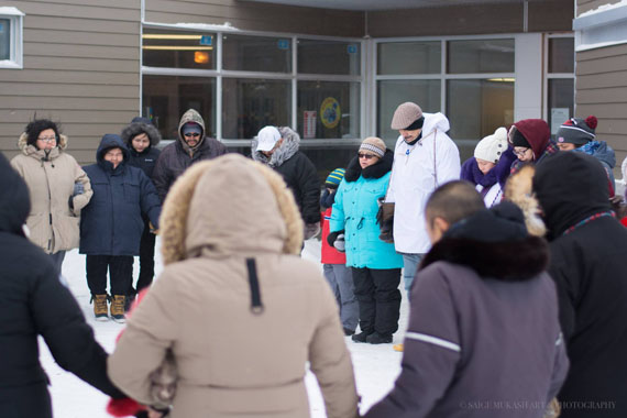 John Clarence Kawapit joins hands with friends and family in prayer Jan. 30 in Whapmagoostui before Kawapit departed on his 12-day walk to Umiujaq. (PHOTO BY SAIGE MUKASH PHOTOGRAPHY)
