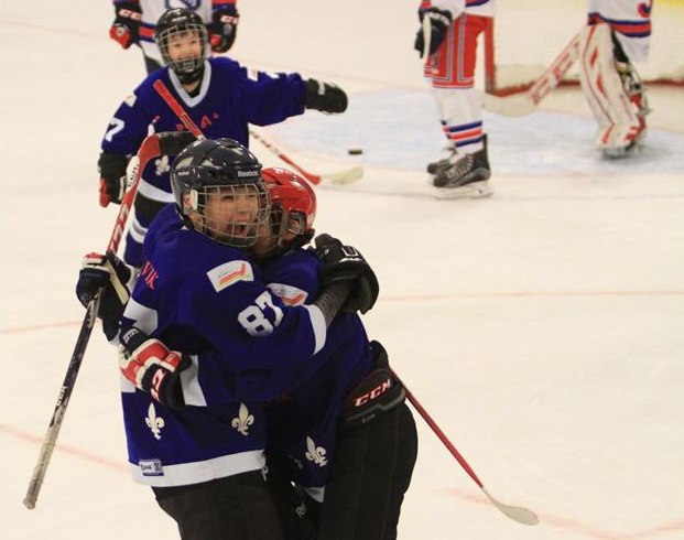 Nunavik Nordiks Peewee Robert Makimmak, left, celebrates a goal with  fellow Nordik on the ice in Lévis, Quebec Feb. 19. The Peewees were playing an international tournament in Quebec last week, but lost their final Feb. 19 game against the North Beauce Rapids 6-5. (PHOTO BY GILLES BOUTIN)