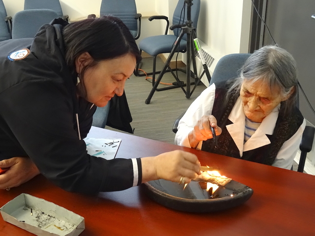NTI President Cathy Towtongie helps an elder light the qulliq in September 2015. Towtongie says the revised Nunavummi Nangminiqaqtunik Ikajuuti policy has been submitted to the Government of Nunavut for approval. (FILE PHOTO)