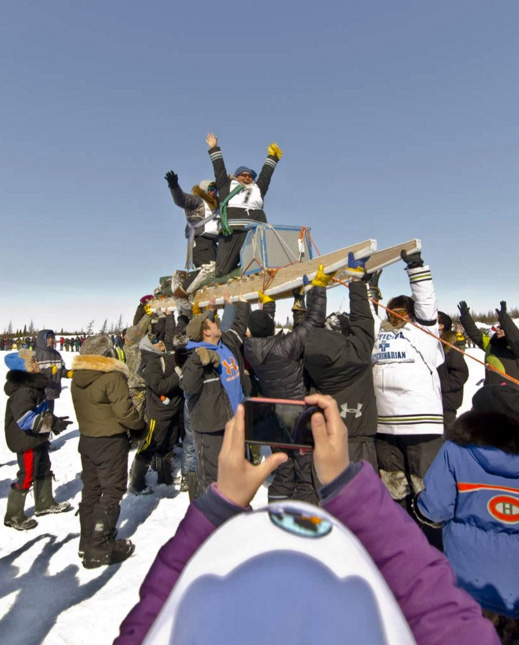 Willie Cain Jr. and Daniel Cain Annahatak arrive at the race’s finish line in Kuujjuaq April 12. As per Ivakkak tradition, mushers are hoisted up on their qamutik at the end of each race. (PHOTO BY PIERRE DUNNIGAN/IVAKKAK)