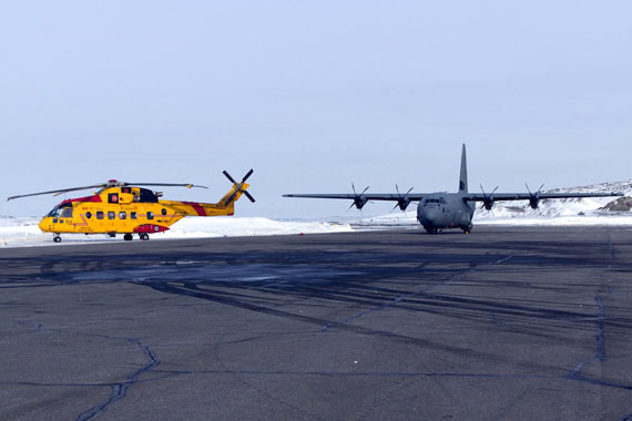A Cormorant helicopter and Hercules aircraft, each of which was used in the recent search for Nunavut MLA Pauloosie Keyootak, sit on the tarmac at the Iqaluit airport. (PHOTO BY BRIAN TATTUINNEE)