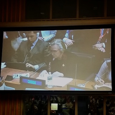A huge screen set up in the UN broadcasts the statement of Min. Carolyn Bennett about Canada's support for the UNDRIP in taken by Aili Keskitalo. the president of the Saami Parliament of Norway.
