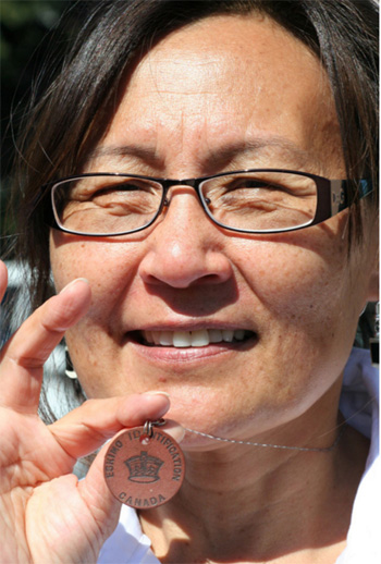 Leena Alivatuk, one of the Ottawa-based Inuit features in Pottle's photo series, wears her identification disc on a necklace. (PHOTO COURTESY OF B. POTTLE/FEHELEY FINE ARTS) 