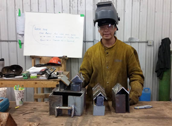 Ian Alikaswa shows off the tiny houses and buildings that make up his metal village Aug. 30 in Arviat, as part of the hamlet's artistic welding workshop, which runs until Sept. 1. (PHOTO COURTESY OF M, MALLA)