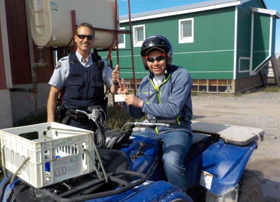 Wanted: Safe drivers. Kugluktuk RCMP Cst. Jeffrey Guenther hands all-terrain vehicle driver Liam Mulgrew a coupon for refreshments at a local store this past week. Throughout July and August, RCMP have partnered with local businesses to promote safe riding in the Kitikmeot community, by patrolling local streets and rewarding safe drivers with coupons, mechanic gloves, helmets and other ATV gear. (PHOTO COURTESY OF NUNAVUT RCMP)