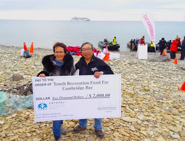 Cambridge Bay Mayor Jeannie Ehaloak and the hamlet's deputy mayor Joe Ohokannoak posed with a cheque for $2,000 they received from Crystal Cruises for the local recreation fund. Crystal Cruises is the company that is running the Crystal Serenity voyage from Alaska to New York City, a month-long luxury cruise and the largest ever tourist ship to ply the Northwest Passage. On Aug. 29 about 600 passengers left the ship to visit Cambridge Bay, where they spent about $100,000, according to local cruise organizer Vicky Aitaok. Read more about the cruise ship's Aug. 29 visit, and its impact on local people and the economy, on Nunatsiaqonline.ca. (PHOTO BY JANE GEORGE)
