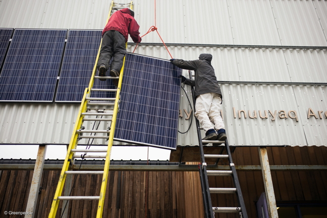 Vancouver Renewable Energy Co-op solar installer Duncan Martin, left, and Greenpeace Logistics Coordinator Claude Beauséjour install solar panels on the Clyde River community hall. (GREENPEACE PHOTO)