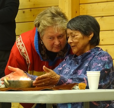 Cambridge Bay cruise ship visit co-ordinator Vicki Aitaok speaks with elder Mary Avalak during a cultural show organized for passengers on the Bremen. (PHOTO BY JANE GEORGE)