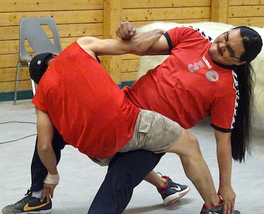 Thomas Kaohina and Ipellie Ootoova demonstrate Inuit games for passengers from the Bremen. (PHOTO BY JANE GEORGE)