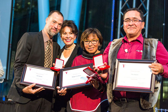 Joé Juneau, left, former National Hockey League player and founder of the Nunavik Youth Hockey Development Program, picks up a 2016 Peace Medal Sept. 21, awarded to him by the YMCAs of Quebec in Montreal. With Juneau, Quebec Judge Louise Otis and NYHDP laureates Maggie Emudluk and Pita Aatami. The group was awarded the Coup de Coeur award for its work running the now 10-year-old hockey program in Nunavik communities, which encourages Inuit youth to stay in school, develop life skills and be healthy. (PHOTO BY CRISTINA STANCIU/YMCA)