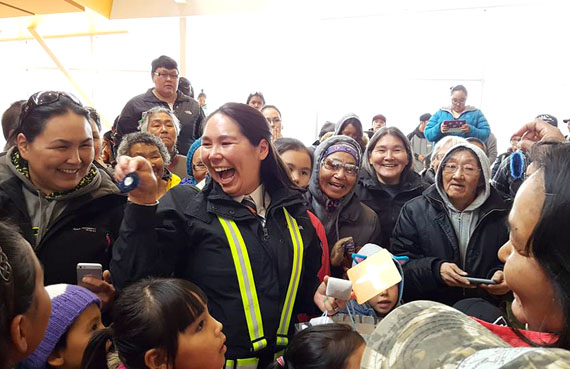 Inukjuak residents gift Air Inuit captain Melissa Haney a pair of earrings Sept. 19 a the community's airport terminal. The community hosted a surprise birthday party for the pilot, who is the first Inuk woman to make Dash 8 captain at the airline. (PHOTO BY CAROLINE OWEETALUKTUK)
