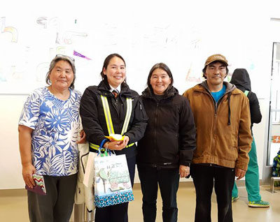 Air Inuit pilot Melissa Haney stops for a photo with her two aunts and uncle during a surprise celebration residents of Inukjuak threw for her on a stop over in the Hudson coast community. (PHOTO BY CAROLINE OWEETALUKTUK)