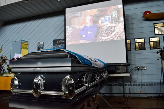 Above the coffin of the late Bryan Pearson, a video tribute to Iqaluit's founding mayor is displayed on a screen at a memorial service held Oct. 17 at the Iqaluit cadet hall attended by hundreds of Iqaluit residents.
