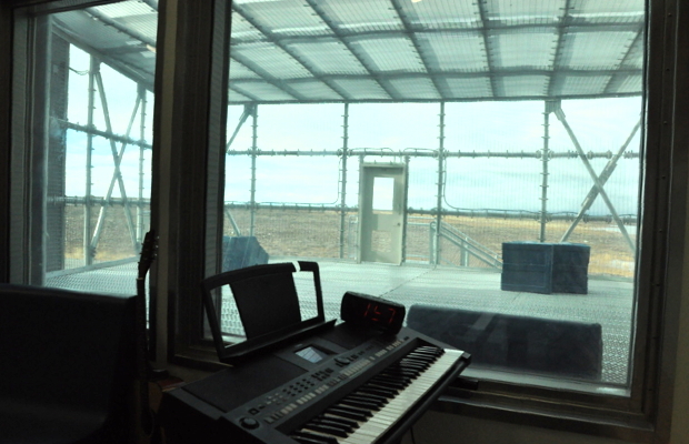 Musical instruments are purchased from the inmates' fund, a collective fund used for recreational purposes. Through the window you can see the fenced in outdoor area where inmates can get fresh air any time they are not locked in their cells which only happens at night and when head counts are conducted prior to staff shift changes.
