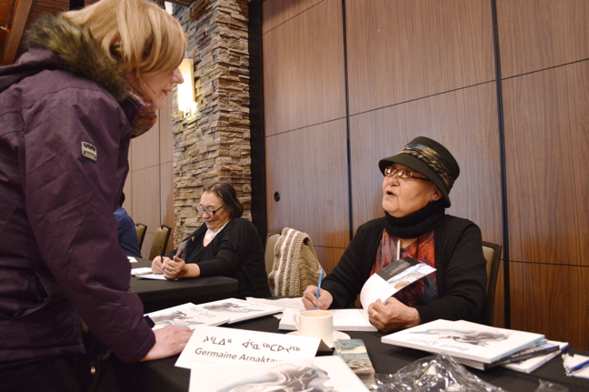 Inuit artist Germaine Arnaktauyok, who, among other achievements, designed the reverse of the two-dollar coin issued by the Royal Canadian Mint in 1999 to commemorate the creation of Nunavut, speaks with fans during a book and print signing, hosted by Nunavut publisher Inhabit Media, in the Koojesse Room of Iqaluit's Frobisher Inn, Feb. 18. Arnaktauyok, and many other Nunavut authors and artists from across the territory, gathered in Iqaluit to promote their most recent publications—part of ongoing events celebrating Inuktitut Language Month. Inhabit Media co-founder Neil Christopher said Nunavut's young publishing industry is slowly, but steadily, coming into its own as a host of multi-generational authors contribute in their own way to Nunavut's literary landscape. Read more later on Nunatsiaqonline.ca. (PHOTO BY STEVE DUCHARME)