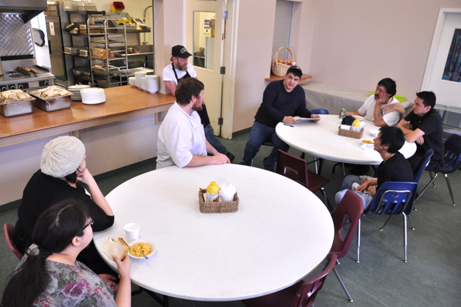 Iqaluit soup kitchen chef Michael Lockley, seated with black sweater and jeans, has lunch with his kitchen team Feb. 27 before they open their doors to the lunchtime crowd. (PHOTOS BY THOMAS ROHNER)
