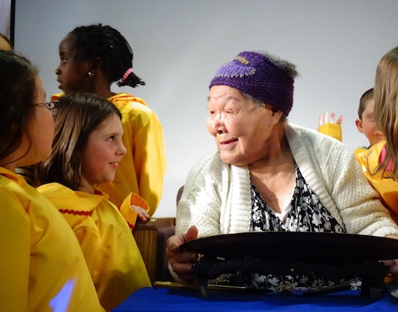 April 27, at the 15th anniversary celebration for Ecole des Trois-Soleils in Iqaluit, elder Alacie Joamie shares a happy moment with a student at the French-language school. (PHOTO BY JANE GEORGE)