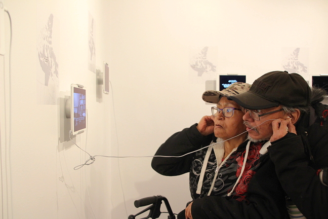 Deborah Qitsualik, left, and Patrick Aula listen to a video from Cambridge Bay at the Nunatta Sunakkutaangit Museum, May 30.