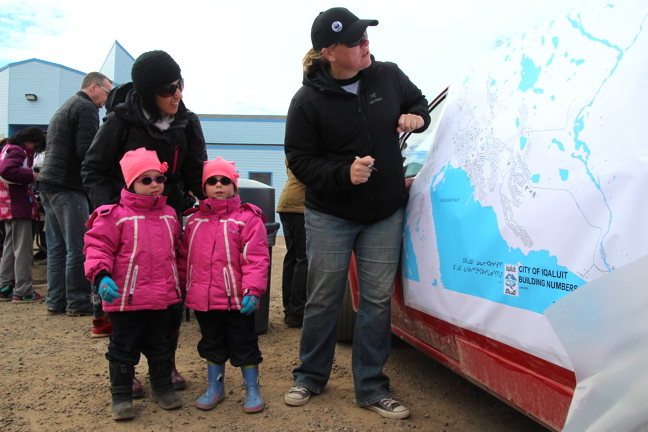 Three-year-old twins Florence, left, and Flavie Parker pick out a place to clean in the plateau with Karine Baron and a clean-up volunteer.