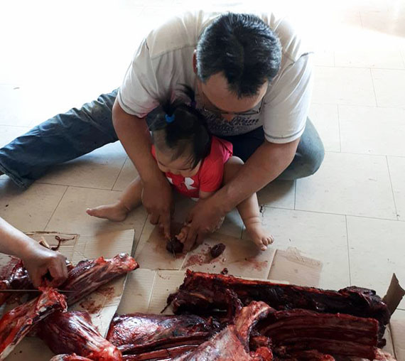 Mamatuq! Wesley Innukshuk Sr. and his infant daughter Mary-Helen enjoy fresh kidney from a caribou the family hunted just outside of Rankin Inlet last month. (PHOTO COURTESY OF VIOLET INNUKSHUK) 
