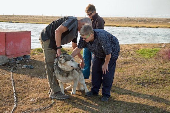 Members of a vet team vaccinate a dog during a house call in the evening after finishing their daily clinic. The team from Alberta Helping Animals Society included Dr. Terry Hunt, Dr. Elaine Degrandpré (in fleece jacket with blue pants in background) and Connie Varnhagen, a registered veterinarian technician (blue scrubs in foreground). (PHOTO BY DENISE LEBLEU IMAGES)