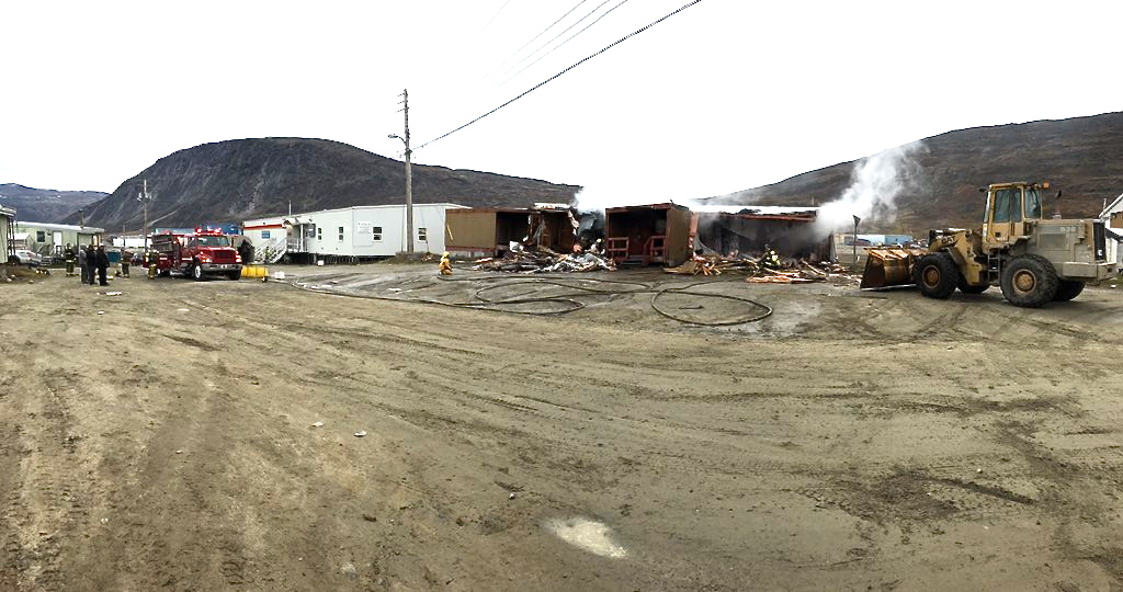 Yet another blaze in Pangnirtung: Firefighters deal with the smouldering remains of a Northern store warehouse early Sept. 8. Since Aug. 21 in Pangnirtung, local fire crews have been called to put out five fires, which the Nunavut RCMP said were “deemed suspicious and are under investigation.