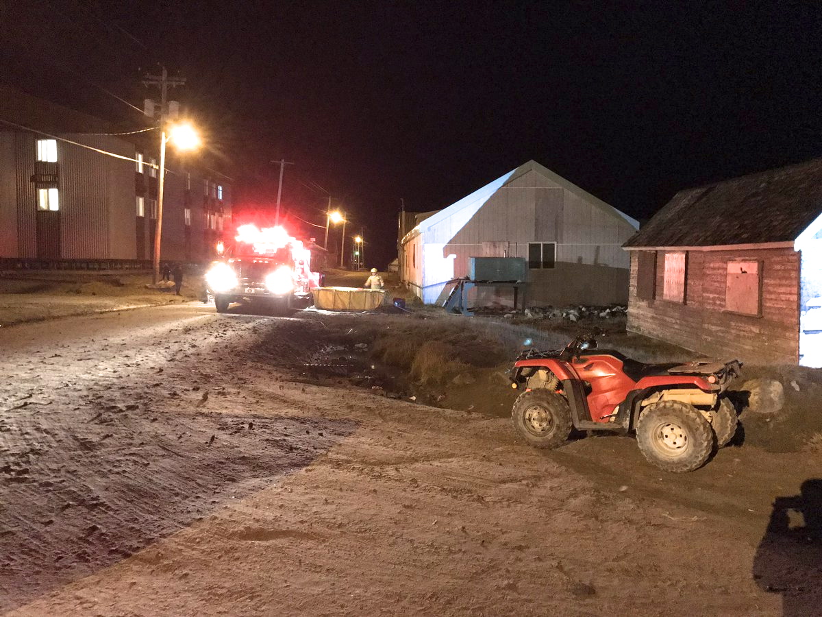 Firefighters deal with a Sept. 15 fire at the former St. Luke's mission hospital in Pangnirtung. (PHOTO BY DANIEL KULUGUQTUQ)