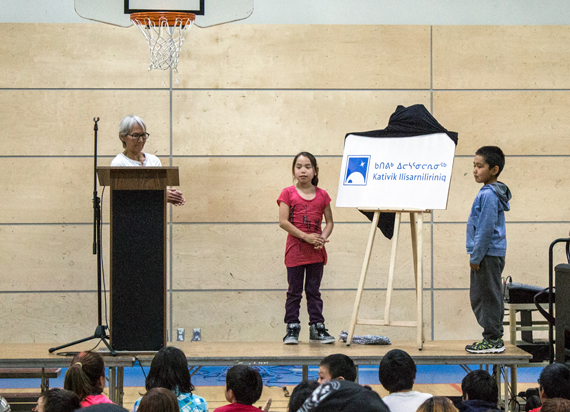 Alicie Nalukturuk, chair of the Kativik School Board, left, helps unveil the board's new logo and name: Nunavimmi Ilisarniliriniq or Nunavik School Board, Sept. 11 at Jaanimmarik school in Kuujjuaq. Until the new name is formally approved, however, the school board will continue to use its current name, Kativik Ilisarniliriniq or Kativik School Board. (PHOTO BY CARSON TAGOONA/KATIVIK ILISARNILIRINIQ)