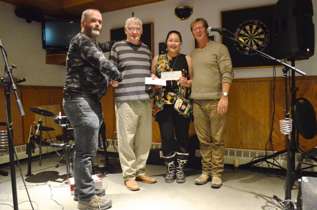 The Qajuqturvik Food Centre, more commonly known as the Iqaluit soup kitchen, received more than $5,000 in donations, gathered over a raucous night of music and fundraising at Iqaluit's Frobisher Bay Elks Lodge, Oct. 13. Above, food centre members Blake Wilson and Tracy Wood accepted cheques from NCC Investment Ltd. and Tumit Development Corp, which donated $500 and $2,500 respectively. In-house 50-50 draws and other donations during the night—organized by Iqaluit city councillor and NWT and Nunavut Chamber of Mines general manager Terry Dobbin—netted the soup kitchen an additional $2,000. (PHOTO BY STEVE DUCHARME)
