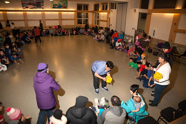 Inuujaq school teachers, and Canada 150 committee members, Sarah Alooloo (left with die), and Eunice Attagutsiak (right, with die), prepare to start a game Nov. 14 at the Arctic Bay community hall.