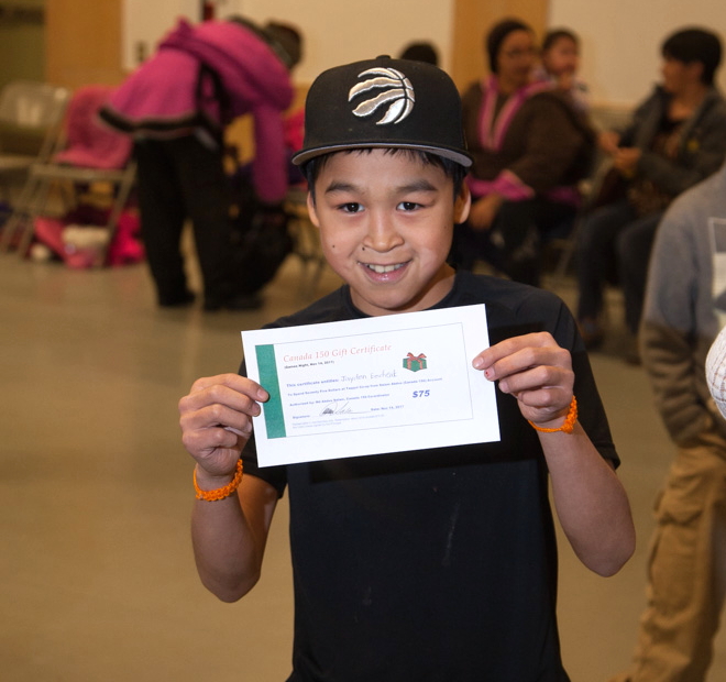 Jayden Eecheak holds up a gift certificate he won during one of the Canada 150 games, Nov. 14 at Arctic Bay.