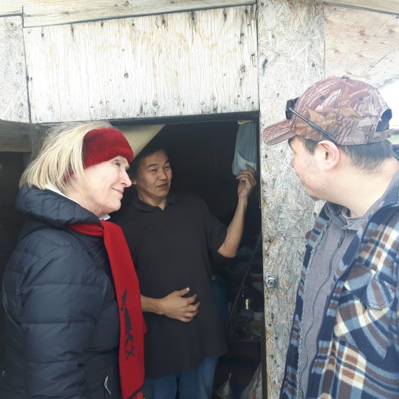 Carolyn Bennett visits Joamie Naglingniq, an Iqaluit resident who has been living in a shack since 2011. This firsthand look at Nunavut’s housing crisis came April 6, during a tour of Iqaluit’s shack community the minister took part in on the request of local activist Qaumariaq Inuqtaqau, right. (PHOTO COURTESY OF THOMAS ROHNER)