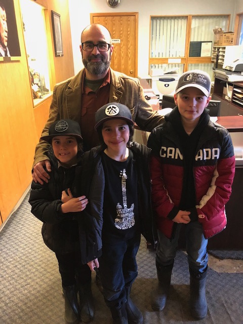 Luc Brisebois and his sons stand in the foyer of Iqaluit City Hall on Tuesday evening. They came to lobby for the Iqaluit skate park to remain open this year. (PHOTO BY JANE GEORGE)