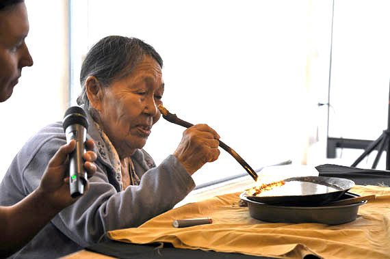 Iqaluit elder Sheepa Ishulutaq lights the qulliq to open meetings of the Arctic Security Working Group in Iqaluit on Wednesday, May 9. The two-day meeting gathers officials from the federal and territorial governments, the Canadian Armed Forces, Coast Guard and Inuit organizations to discuss Arctic climate change and maritime search and rescue strategy. (PHOTO BY SARAH ROGERS)