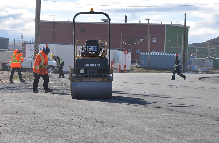 Smooth sailing: Crews put the finishing touches on the newly paved section of Federal Road in Iqaluit, parts of which are now open to traffic. Earlier this year, the city was approved a $2.5 million grant to re-pave the pothole-ridden road, which leads to Iqaluit's new airport, from Qaqqamiut Road to Ikaluktuutiak Drive. (PHOTO BY SARAH ROGERS)