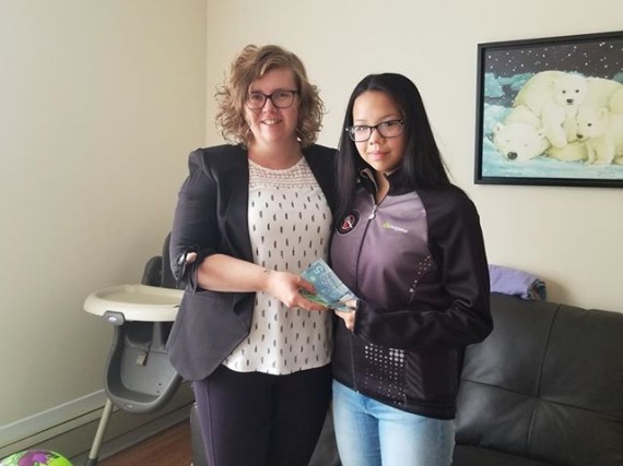 Kimberly Yvonne, left, a supervisor at Iqaluit's Qimaavik shelter, receives a donation from Savannah Eetuk-Ell of Nannaaqs Cakes last week. The 13-year-old baked two cakes, raffled them off and raised $165 for the Apex emergency women's shelter. (PHOTO COURTESY OF JOHN EETUK)